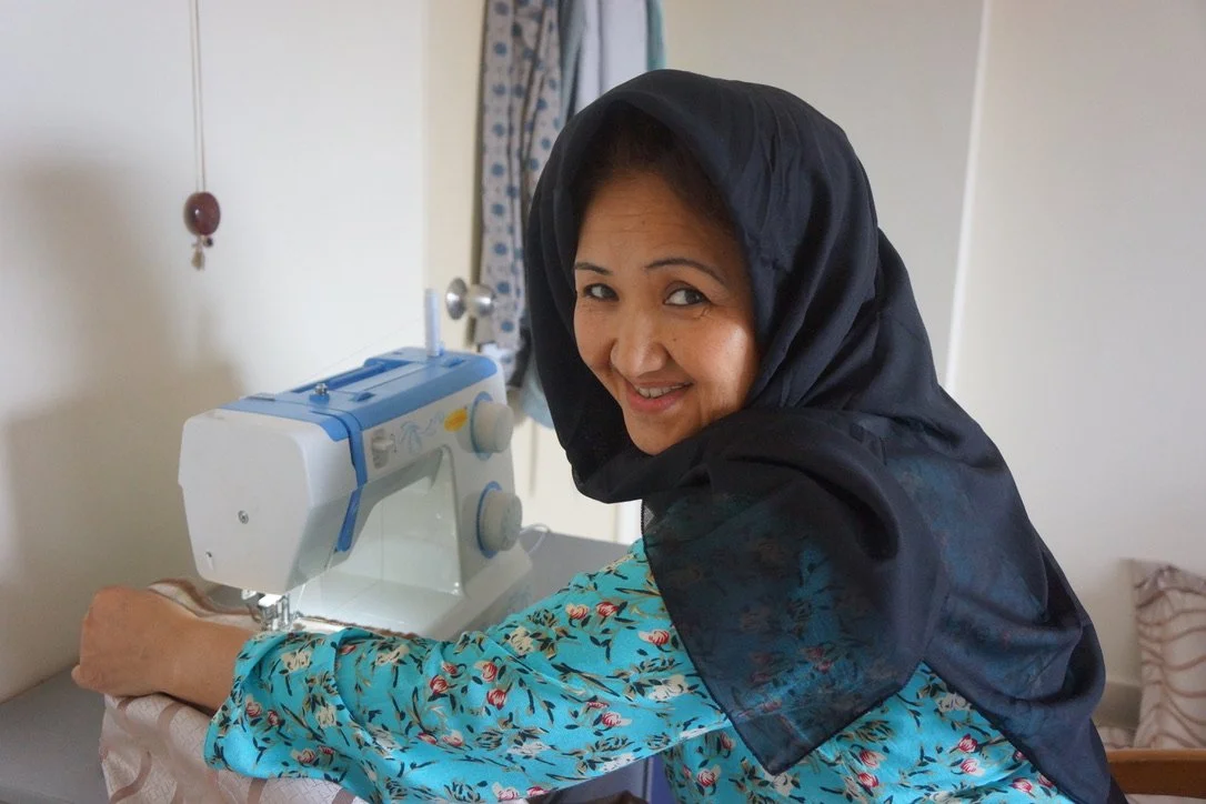 A refugee entrepreneur running her tailoring business